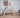 A toddler climbing on a wooden Pikler Triangle in a bright Montessori-style playroom, developing balance and motor skills.