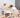 Alt text: Two young children standing on wooden Montessori learning towers while baking together at a kitchen table.